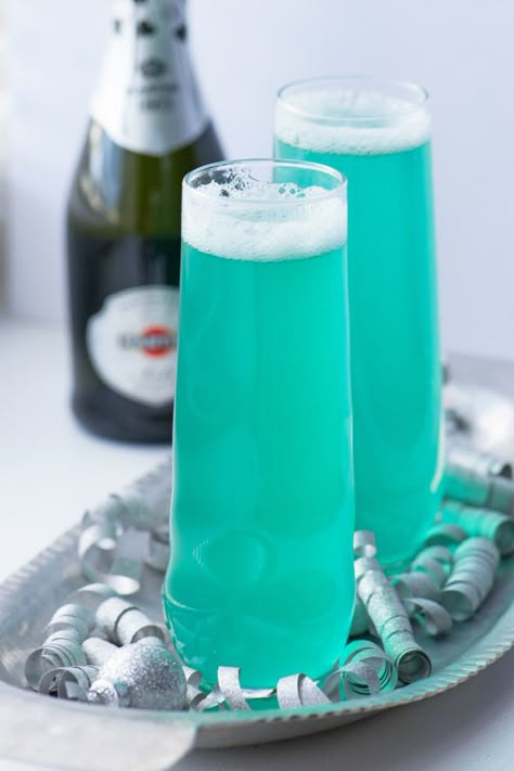 The secret to making this turquoise drink? One tablespoon of blue Curacao. New Years Eve Drinks, New Year's Drinks, Champagne Recipes Cocktails, Blue Drinks, Champagne Cocktail, Blue Curacao, Pool Bar, Holiday Drinks, Adult Drinks