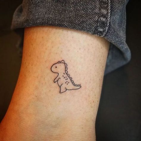 Tattoo Ideas Female Dinosaur, Cartoon T Rex Tattoo, Dino Flower Tattoo, Velociraptor Tattoo Cute, Dinosaur Egg Tattoo, Small Trex Dinosaur Tattoo, Rainbow Dinosaur Tattoo, Cute Tiny Dinosaur Tattoos, Tiny Trex Tattoo