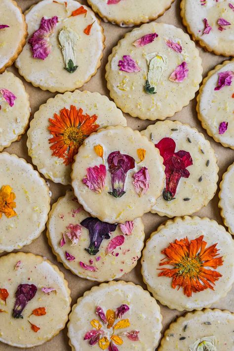 Edible Flower Shortbread Cookies are beautiful and delightful melt-in-your-mouth cookies. They feature sweet lemon shortbread dipped in a sweet lemon vanilla bean glaze adorned with pressed flowers. This surprisingly simple recipe only requires a few steps and is perfect for hosting and gifting. Flower Cookies Recipe, Cookies With Flowers, Flower Shortbread Cookies, Flower Shortbread, Spring Flower Cookies, Lemon Shortbread, Dipped Cookies, Buttery Cookies, Sweet Lemon