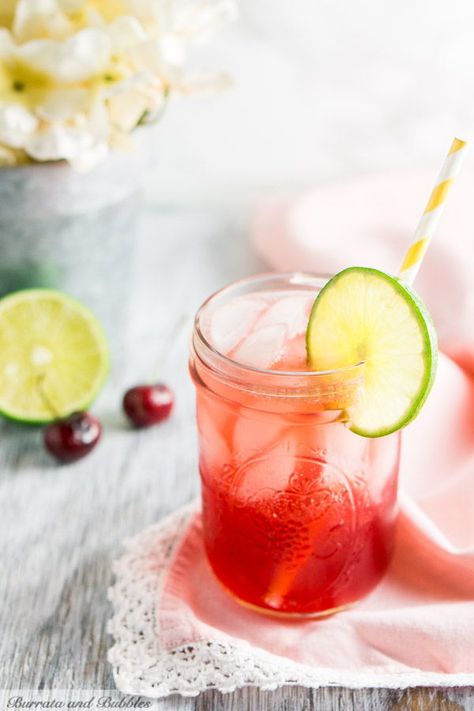 I love a good Sonic cherry limeade, but I love it even better with bourbon. This bourbon cherry limeade is a fun twist on a classic.  #BurrataAndBubbles #SonicCherryLimeadeRecipe #CherryBourbon #CherryBourbonCocktail  #BourbonCocktails #CocktailRecipes  #CherryCocktailRecipes #CherryLimeadeRecipe #CherryLimeadeRecipeAlcohol Cherry Cocktail Recipes, Cherry Limeade Recipe, Sonic Cherry Limeade, Bubble Recipe, Bourbon Cherries, Easy Summer Cocktails, Light Appetizers, Slice Of Lime, Cherry Limeade