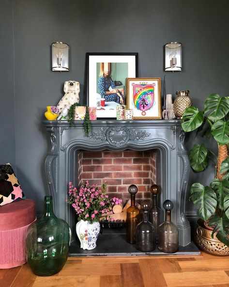 Layer artwork, houseplants and decor for a maximalist look. Quirky Mantle Decor, Mantel Decorating Ideas Maximalist, Witchy Mantel Decor, Mantle Decor Maximalist, Maximalist Decor Fireplace, Maximalist Fireplace Decor, Eclectic Fireplace Mantle Decor, Maximalist Fireplace Mantle, Eclectic Mantel Decor