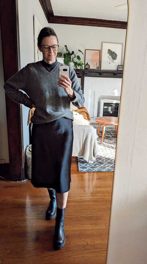 Comfortable teacher outfit with a black satin midi skirt, v-neck sweater and combat boots Comfortable Teacher Outfits, Casual Teacher Outfit, Black Satin Midi Skirt, Chic Winter Outfits, Cozy Coats, Trendy Sweaters, Teacher Outfit, Satin Midi Skirt, Cold Weather Fashion