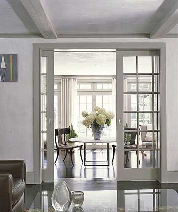 Paned-glass Pocket Doors  What's more convenient than doors that disappear when you don't need them? That's the beauty of pocket doors. These paned-glass interior doors mimic the home's exterior windows. Leading from the living room, the pocket doors open on to an airy sunroom with casual dining and sitting space. Sliding Doors Dining Room, Kitchen Living Room Divider Sliding Doors, Sliding Glass Doors Dining Room, Grey French Doors Interior, Lounge To Dining Room Doors, Internal Sliding Doors Room Dividers, Pocket Doors With Glass Panels, Double Door Interior, Cavity Sliders