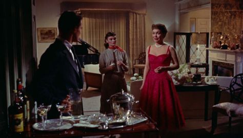 All That Heaven Allows (1955) - Jane Wyman and Gloria Talbott as Cary Scott and her daughter Kay wear red in scenes dealing with marriage.  Cary wears a dress with full skirt and double-strap bodice to go to a club with her suitor Harvey; at the end of the evening she will turn his marriage proposal down. On the contrary Kay wears a shawl-collar dress with full skirt on the day she announces shes getting married. Both women accessorise their scarlet outfits with pearl necklaces.  The costumes we Outfit With Pearl Necklace, Outfit With Pearls, All That Heaven Allows, Jane Wyman, Film Costumes, Marriage Proposal, Wear Red, Pearl Necklaces, Wearing Red