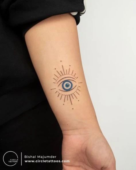 The Evil Eye Tattoo Meaning And 55+ Designs That Offer Protection Evil Eye Tattoo With Color, Pink Evil Eye Tattoo, Evil Eye Knee Tattoo, Evil Eye Neck Tattoos Women, Unique Evil Eye Tattoo, Evil Eye Dream Catcher Tattoo, Evil Eye Neck Tattoo, Greek Eye Tattoo, Greek Evil Eye Tattoo