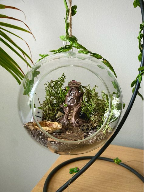 Hanging glass globe with mini fairy house and garden inside. Assorted “lost" objects as decor such as dice, gears, and mini dominoes. Dollar Tree Witchy Decor Diy, Dollar Tree Cottagecore, Dollar Tree Terrarium Diy Projects, Dollar Tree Terrarium, Labyrinth Room, Fake Terrarium, Crystal Terrarium Diy, Witchy Decor Diy, Fairy Globe