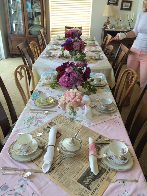 Vintage linens are used to top this tea party table, along with pages from a newspaper dated 1947. Teacups and saucers are set up mix and match for a shabby chic look.  Sterling spoons were bent into circles for napkin rings, with vintage shell buttons as decoration. Mix Match Tea Party, Mix Match Tea Party Table Settings, Table Setting Guide, Tea Party Table Settings, Jazz Night, Group Dinner, Vintage Table Setting, Paper Tablecloth, Tea Party Table