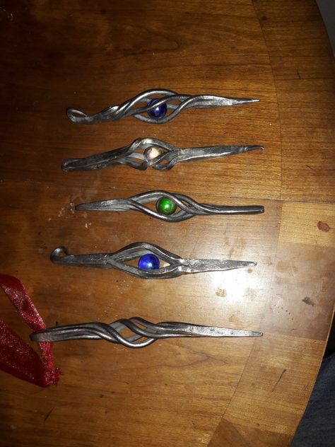 Assortment of forged Christmas ornaments, made from 3/16" round and square stock, forge welded at the ends. Forged Christmas Gifts, Hand Forged Christmas Ornaments, Blacksmith Christmas Ornaments, Forging Projects, Weld Projects, Forging Ideas, Marble Ornaments, Forge Ideas, Blacksmith Ideas