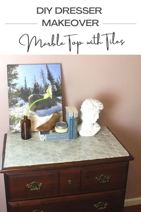 A dresser has been transformed with marble tiles for an antique look and has been styled with books, a portrait, and a vase of a flower. Tile Dresser Top Diy, Antique Marble Top Dresser, Marble Dresser Top, Tile Top Dresser, Marble Top Dresser Makeover, Tiled Dresser, Tile Dresser, Marble Top Dresser, Top Of Dresser