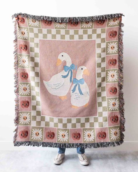 The Silly Goose Blanket is a charming, sweet, and fun way to stay cozy. A light pink background is the backdrop for a playful retro design, showcasing cute silly geese and a checker border (including cheerfully smiling apples and flowers). Woven from 100% cotton threads, not printed, it offers beautiful texture and depth of color. The nostalgic retro pattern is light-hearted and comforting, ideal for young ones and adults alike. Bring this delightful blanket into your home, or send it as a sweet Pastel Farmhouse, Country Cottagecore, Maximalist Eclectic, Cute Goose, Checkered Decor, Silly Goose, Cotton Throw Blanket, Nursery Inspo, Farmhouse Country