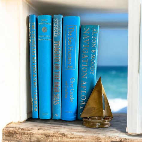 Nautical titled vibrant blue books set for coastal home decor. This is a collection of 8 beach, ocean or sea themed books in bright marine blues, vintage and modern mix. They are REAL books for reading, collecting, home staging, photography props, bookshelf styling, home library designing or table accent decor. Good condition! They are authentic, readable books in beautiful blues ALL with nautical, beach or coastal titles!  What a fun and unique way to decorate your table or shelves, especially in a beach house or coastal home! Great collection as they are all in good condition! Great for reading and/or decorating! The collection you receive is EXACTLY AS PICTURED When standing up side by side, this collection measures 6 inches across, 9 and 1/2 inches tall and 7 and 1/4 inches deep.  Plea Nautical Shelf, Books For Reading, Staging Photography, Shelf Decorations, Shelf Home Decor, House Shelves, Coastal Home Decor, Bookshelf Styling, House Book