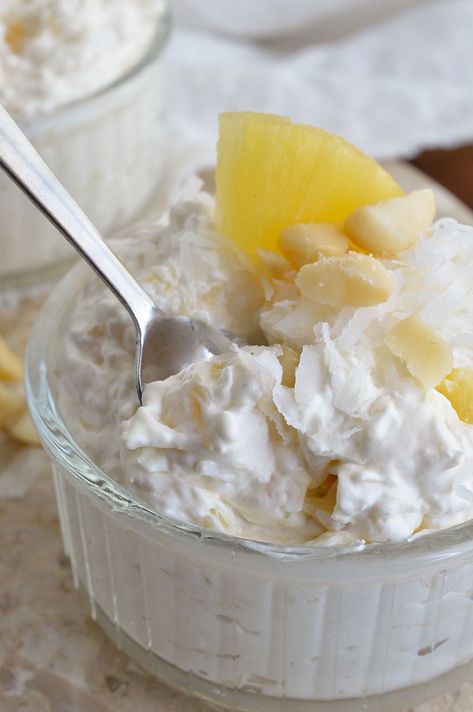 This Coconut Pineapple Fluff Recipe is light, airy and full of flavor! Coconut and Pineapple whipped with cream cheese and Cool Whip then topped with macadamia nuts. Serve straight from the bowl or as a dessert dip. Cream Cheese Cool Whip Dessert, Cool Whip Dessert Recipes, Cool Whip Frosting Recipe, Pineapple Fluff Recipe, Pineapple Fluff, Cool Whip Desserts, Pineapple Whip, Fluff Recipe, Pineapple Recipes