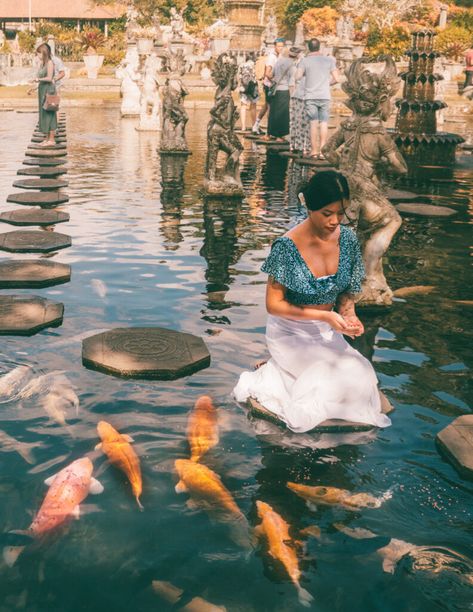 a girl feeding koi fish in a pond at a balinese temple called tirta gangga in bali Tirta Gangga Bali, Koi Fish In A Pond, Fish In A Pond, Tirta Gangga, Thai New Year, Travel Romance, Bali Girls, Temple Bali, Travel Bali