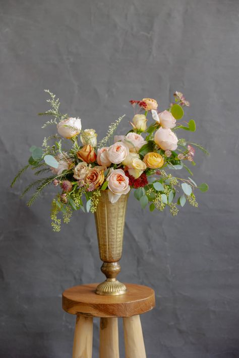 Garden style wedding arrangement in gold pedestal vase feautring soft pink garden roses, peach ranuculus, seeded eucalyptus, soft yellow roses  and more. Garden Style Wedding, Gold Pedestal, Gold Urn, Pedestal Vase, Flower Vase Arrangements, Florist Supplies, Vase Arrangements, Wedding Arrangements, Garden Styles