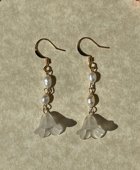 This pair of White Lilium Earrings features freshwater pearls set in a floral dangly design. The unique style offers a perfect balance of luxury and subtle sophistication in a fresh, white design. The freshwater pearls offer a timeless look that will never go out of style. Also available in dark green and light blue. These are made-to-order. Features:☘︎ 14k gold-filled hardware☘︎ lucite flowers☘︎ freshwater pearls Length: ~2 in Dainty Dangly Earrings, Pretty Jewellery Earrings, White Lilium, Dangly Pearl Earrings, Grad Jewelry, Whimsical Earrings, Lucite Flowers, Fairy Earrings, Acrylic Flower