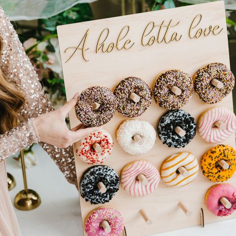 ❤ Donut wall - the ultimate display solution for showcasing delicious treats at  events, parties, and weddings. Crafted with high-quality materials and a stylish  design, this stand adds a touch of charm to any dessert spread.  ❤ We offer four unique design options and a variety of text choices, allowing you to  select the perfect combination that complements your party theme or event, whether  it's a donut party, bridal shower, first birthday, or baby shower decor. With our range  of designs an Fall Donut Wall, Donut Stand Display, Donut Cart, Decorations For Wedding Reception, Donut Holder, Table Display Stand, Dessert Table Display, Fall Baby Shower Themes, Donut Display