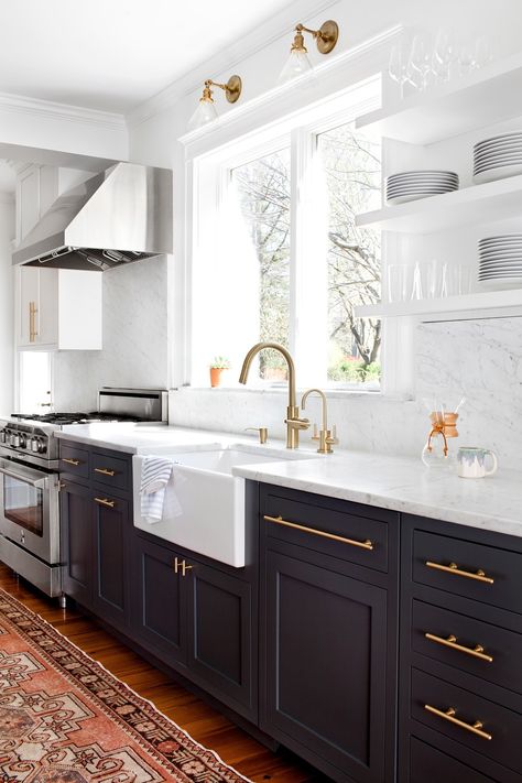 A kitchen renovation with dark gray lowers cabinets and white uppers, satin brass hardware and a continuous Carrara marble backsplash, that has a modern sensibility, but feels timeless. A vintage oushak creates warmth underfoot. White Uppers Black Lower Cabinets, White Uppers Black Lowers, Black Lower Cabinets White Upper, Tuxedo Kitchen Cabinets, Black Lower Cabinets, Tuxedo Kitchen, Carrara Marble Backsplash, Kitchen 2025, Satin Brass Hardware