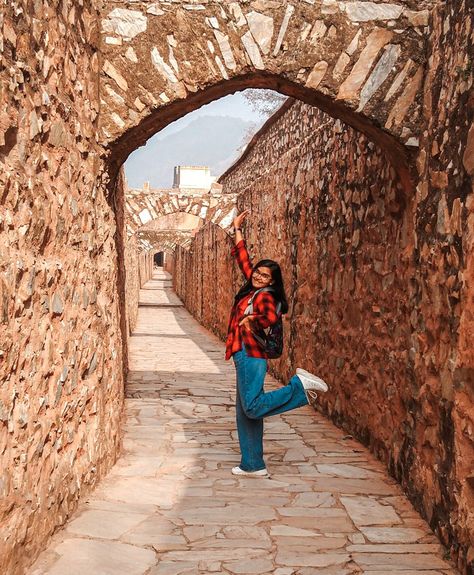 Wearing denim wide-leg pants, red and black striped flannel with a black camisole, a black wristwatch, and white chunky sneakers. Amer Fort Jaipur, Casual Outfits For Girls, Jaipur Travel, Photo Styles, Amer Fort, Travel Pictures Poses, Pictures Poses, Picture Story, Bangles Jewelry Designs