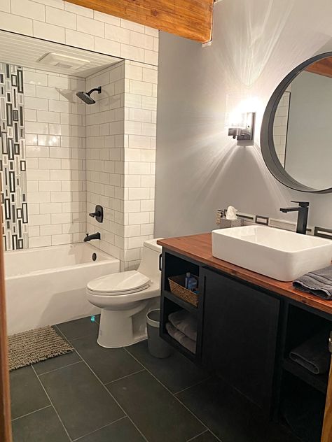 Black Vanity With Wood Top, Tile Shower Surround, Wood Vanity Top, Painted Wood Ceiling, Ceramic Waterfall, Black Round Mirror, Black Fixtures, White Vessel Sink, Slate Floor