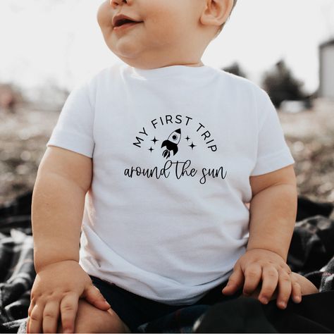 Celebrate your toddler's first trip around the sun with this adorable rocket-themed t-shirt! 🚀 Perfect for little explorers and space enthusiasts. Available in various sizes. #toddlerfashion #rocketshirt #firstbirthday #spaceexplorer #toddlerstyle  Please note that the Pin URL is an affiliate link. Bday Themes, Toddler Ootd, Sun Birthday, First Trip Around The Sun, Sun Design, Toddler Tops, Cadeau Photo, Birthday Themes, Trendy Kids