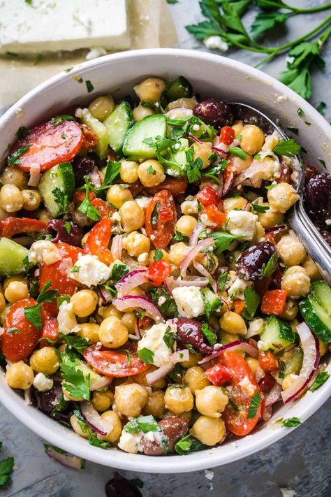 Whip up this easy and irresistible Greek chickpea salad with tender chickpeas, cucumbers, tomatoes, Kalamata olives, feta, and zingy Greek dressing. It's a Mediterranean delight! Salad Recipe With Chickpeas, Garbanzo Beans Salad, Greek Chickpea Salad, Greek Chickpeas, Mediterranean Chickpea Salad, Greek Dressing, Green Salad Recipes, Chickpea Salad Recipes, Greek Salad Recipes