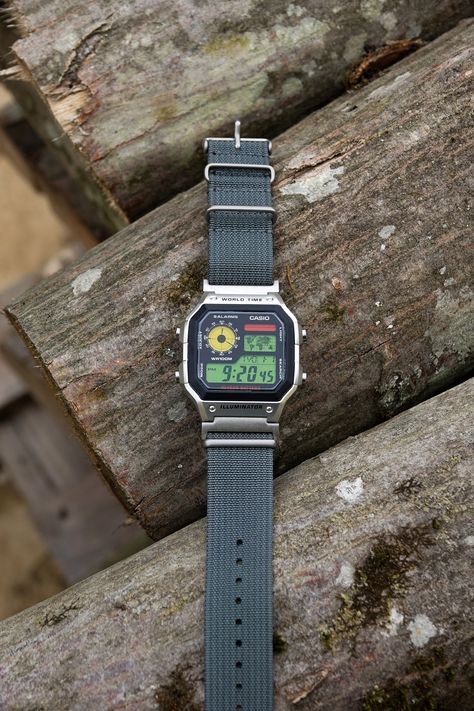 "Casio Custom Hydro Mod Royale AE1200 \"Urban Cruiser 22mm\" Watch Red, Yellow and Green Screen - Nylon Strap Digital Casio AE-1200W Vintage This is a custom watch Casio AE-1200 (Royale) that has a tri-tone red, yellow and green screen and a new 22mm nylon durable gray strap to complement desert colors and feel.  Strap is changed on this model of Royale, previous had 18mm strap on original lugs, but we have fitted 18 to 22mm silver colored adapters in order to conserve a beautiful 22mm form of the watch case endings. OPTIONAL: This one can also be oil-filled (hydromod) to increase contrast and water resistance to 200m worth of pressure. Great for outdoor activities. Stopwatch, alarm and 31 world zones. It's a digital watch that can be unique holiday gift. All our watches can be made as a p Casio Ae1200 Mod, Casio Ae1200, Casio Royale, Vintage Casio Watch, Casio Digital Watch, Digital Watches For Men, Casio Vintage Watch, Casio Digital, Outdoor Watch