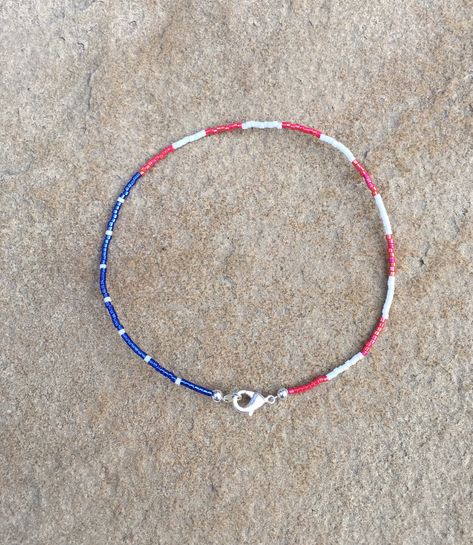 This is a dainty red, white, and blue ankle bracelet. The blue bead background with white beads interspersed depicting the stars and the red and white bead the stripes of the flag. Would make a great 4th of July anklet, or wear all year long showing your American pride. It is sturdy, and is made with tiny delica beads on wire with a silver plated lobster claw clasp. Minimalist anklet. This would also make a great delicate bracelet or choker. Mundo Hippie, Minimalist Anklet, Patriotic Bracelet, Ankle Bracelets Diy, Country Jewelry, Beaded Jewelry Necklaces, Beaded Necklace Designs, Necklace Ideas, Beaded Necklace Diy