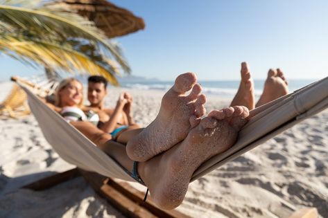 Caucasian couple enjoying time at the beach, lying on a hammock, embracing and holding hands Enjoy Time, Hammock, At The Beach, Holding Hands, A Photo, The Beach, Outdoor Decor