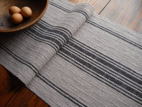 In rich neutral tones of dark taupe and black, this rustic woven table runner brings a warm, farmhouse look to any dining room. Woven entirely by... Weaving Towels, Hole Photography, Hand Woven Table Runner, Rigid Heddle Weaving Patterns, Weaving Studio, Farmhouse Table Runner, Rustic Table Runners, Farmhouse Table Runners, Woven Textiles