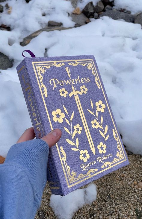 A handmade rebound book of Powerless by Lauren Roberts. Item is made with: -Gold foil heat transfer vinyl on the front cover, back cover, and spine.  -Purple book cloth surrounds the book cover.  -Black and white flower end pages (of my choosing).  -Purple ribbon attached to the spine for a bookmark.   This is the paperback edition of the book so the sizing will match that with the original paperback.  Each special edition is made to order, so please be patient with ordering. Orders may take 1-3 Books Front Cover Design, Painted Book Spines, Books With Cool Covers, Powerless Special Edition, Books With Black Pages, Unique Book Covers, Rebound Book Covers, Powerless Book Cover, Books Special Editions