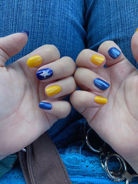 blue and yellow alternating nails, the middle finger on the left hand blue with a white star painted on it Easy Coraline Nails, Short Coraline Nails, Simple Coraline Nails, Coraline Nails Short, Coraline Themed Nails, Coraline Triangle, Coraline Inspired Nails, Coraline Nails Art, Fnaf Nails