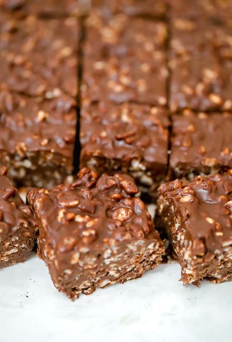 "We are totally addicted to these Easy Chocolate Peanut Butter Crunch Bars!   All it takes are 5 ingredients and the stars of the show are the delicious combination of crispy cereal, chocolate and peanut butter!  Seriously, this candy can be made with minimal effort and its no-bake!  These thick and luscious, rich chocolate dessert bars have a crispy, crunchy bite and they are amazing.   Grab a bar or two whenever you want a sweet tooth fix. You wont believe how good they taste and it will soon Chocolate Crispy Bars, No Bake Crunch Bars, Chocolate Dessert Bars, Chocolate Peanut Butter Crunch Bars, Peanut Butter Crunch Bars, Crunch Bars Recipe, Traybake Cake, Chocolate Dessert Bar, Rich Chocolate Dessert