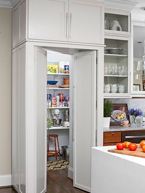 Hide a walk-in pantry built behind the kitchen walls by installing an upper cabinet with cabinet-look doors below. This fool-the-eye solution provides extra storage in the bulkhead and a seamless look in the kitchen. When a pantry lacks windows, it's important to add ample overhead lighting. Distressed Kitchen Cabinets, Pantry Layout, Food Storage Cabinet, Distressed Kitchen, Upper Cabinet, Hidden Pantry, Kitchen Walls, Kitchen Pantry Design, Kitchen Pantry Cabinets