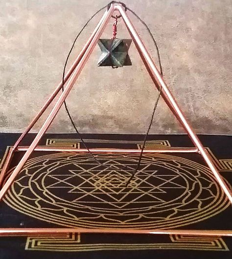 Harmonize your home with this large solid  COPPER PYRAMID. About 8.5" from point to point measured diagonally on the base. Each side is about 6" and it's about 5" high, accurate within 1/8". I offer an optional Sri Yantra or Metatron's Cube energy mat or alter cloth and a copper wrapped PYRITE or BLACK TOURMALINE MERKABA to hang from the top. The Sri Yantra and Metatron mats are made of cotton and is 12" on all sides. The merkaba is copper wrapped and includes a piece of black hemp cord to tie i Copper Pyramid, Energy Symbols, Ancient Pyramids, Metatron's Cube, Metatrons Cube, Platonic Solid, Power Of Meditation, Sri Yantra, Hemp Cord