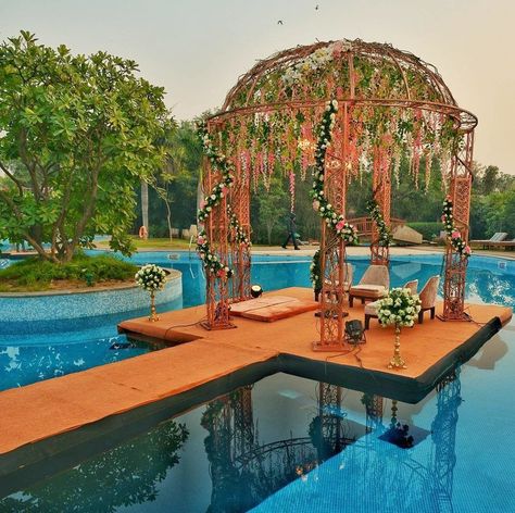 A floral dream floating mandap in the middle of the pool.  #mandap #weddingmandap #shaadisaga #weddingdecor #weddinginspo #mandapideas Floating Stage Wedding, Stage Over Pool Wedding, Pool Mandap Decor, Pool Wedding Ideas, Floating Mandap, Mandap Decor Indian, Pool Wedding Decorations, Mandap Design, Wedding Setup