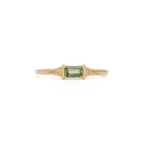 Exquisite and versatile, this dainty ring is a piece any lover of jewelry will adore. A vibrant green sapphire, nestled in Jennie Kwon's iconic deco setting, creates a captivating focal point. Perfectly suited for everyday wear, this ring can grace any finger or shine as a unique engagement option. Crafted in the U.S.A. from 14 karat gold, it features a 5 mm x 3 mm green sapphire and two shimmering 1.2 mm diamonds. Dainty Sapphire Engagement Ring, Dainty Emerald Engagement Ring, Small Emerald Ring, Green Sapphire Ring Engagement, Senior Ring, Green Diamond Engagement Ring, Engagement Rings Green, Green Engagement Ring, Senior Rings