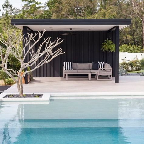 a minimalist black pool cabana with striped pillows on a single upholstered sofa for those who dont' like anything excessive Pool House Ideas Backyards, Cabana Ideas Backyard, Modern Pool Cabana, Pool Cabana Ideas, Pool Gazebo, Pool Pergola, Modern Pool House, Simple Pool, Pool Diy