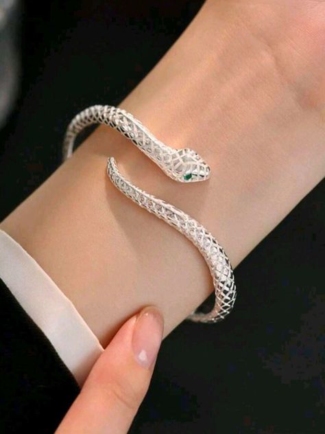 Unleash your inner serpent with this Adjustable Silver Snake Bangle! Featuring a sleek, coiled design that wraps gracefully around your wrist, this bangle symbolizes transformation and power. Its adjustable fit ensures it slips comfortably onto any wrist, making it a versatile accessory for any outfit or occasion. Whether you're drawn to its bold, edgy look or its deeper symbolism of rebirth and resilience, this snake bangle is a statement piece that commands attention. Embrace your unique style and let this serpent be a stylish reminder of your strength and evolution. Make it yours today! Ouroboros Bracelet, Ouroboros Jewelry, Cool Bracelets, Chunky Silver Bracelet, Gifts For Young Women, Silver Snake Bracelet, Silver Bracelet Designs, Snake Bangle, Bracelet Trendy