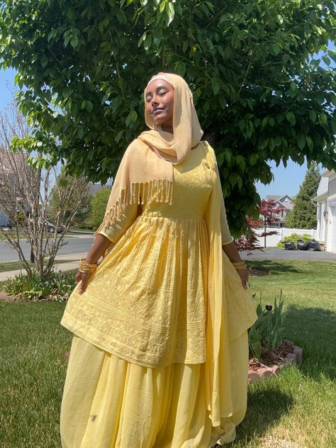 a beautiful dark south asian girl wearing a yellow flowy ghararah with a golden hijab, in the grass field in front of a small tree, she is smiling with her eyes closed looking up at the shining sun that is lighting up her glowing face Hijabi Yellow Outfit, Yellow Desi Dress, Yellow Desi Outfit, Desi Party Wear, Yellow Hijab Outfit, Desi Hijabi, Aesthetic Eid, Yellow Hijab, Eid Dress Ideas