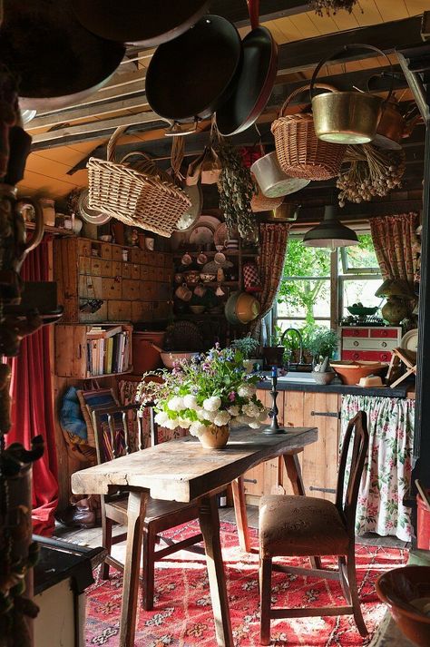 Baskets and pans hanging from ceiling above rustic dining table and chairs Hanging Baskets Kitchen, Hanging Wicker Baskets, Hanging From Ceiling, Witch Cottage, Interior Design Images, Kitchen Ceiling, Deco Boheme, Rustic Kitchen Decor, The Ceiling