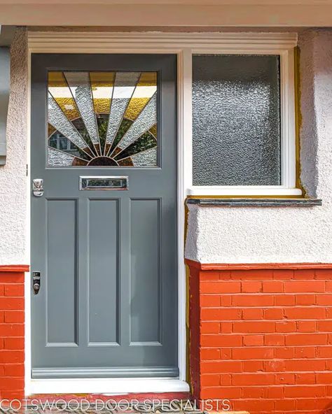 A sleek 1930s sunburst door painted in soft smoke grey. The distinctive stained glass panel design with its symmetrical sun rays is typical of the 1930s aesthetic, which favoured bold colours and strong shapes. Textured glass improves privacy for the homeowner, while also maintaining light flow through to the interior. A brand new frame has been installed along with the door, and features a single large sidelight of textured glass. Interior Wooden Doors With Glass Panels, Stained Glass Doors Interior, Sunburst Door, Craftsman Style Front Door, Art Deco Front Door, 1930s Aesthetic, 1930s Doors, Yellow Front Door, American Craftsman Style