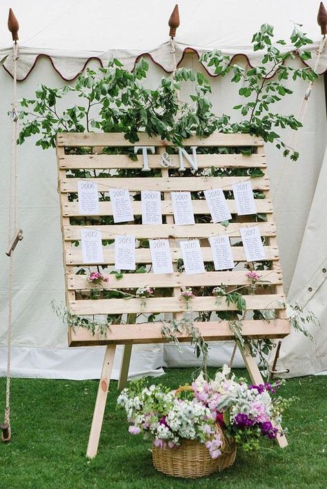 Picture of a wedding seating chart with a pallet on stands and monograms and much greenery Country Wedding Decor Ideas, Pallet Stand, Rustic Wood Wedding Decor, Wedding Table Planner, Wedding Pallet, Country Wedding Decor, Table Planner, Pallet Wedding, Diy Wedding Table