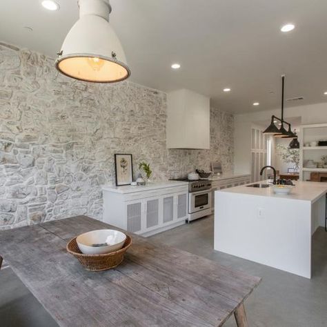 Picture Of a kitchen and dining zone done in modern farmhouse style with a whitewashed stone accent wall that sets the tone and atmosphere here Leanne Ford Kitchen Design, Stone Accent Wall, Gray Floors, County Kitchen, White Kitchen Rustic, Rock The Block, Ford Interior, Stone Accent Walls, House Beautiful Magazine