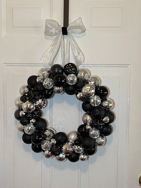 This one of a kind Ornament Wreath was constructed with shatterproof ornaments which will ensure it lasts many holiday seasons. It is truly one of a kind as we handcraft each of our wreaths with creativity, love and care. READY TO SHIP! - will send within 24 hours of ordering. Name: Midnight Elegance Main Color theme: Black & Silver Approx. 18 inches around and 4 inches deep PLEASE READ: Gorilla glue was used in the construction of this item. Please be aware that hot glue may not hold up under extreme weather conditions, including high heat, freezing temperatures, or heavy moisture. As temps go up/down the strength of a hot melt adhesive goes down as it loses its ability to hold two substrates together solidly. Please consider this when storing and displaying your wreath(s). For best resul Black And Silver Christmas Decor, Black Christmas Wreath Ideas, Black Christmas Reef, Black Bauble Wreath, Black And Silver Christmas Wreath, Black And White Ornament Wreath, Black And Silver Christmas, Minimalist Ornaments, Sunrise House