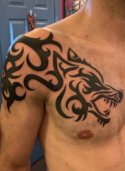 Wolf Tattoos - What's their Meaning? PLUS Ideas & Photos Tattoo Designs Men Wolf, Wolf Tattoos Men Chest, Wolf Chest Tattoo Men, Alpha Wolf Tattoo Men, Shoulder And Chest Tattoo, Trible Tattoos For Men, Alpha Wolf Tattoo, Celtic Wolf Tattoo, Trible Tattoos