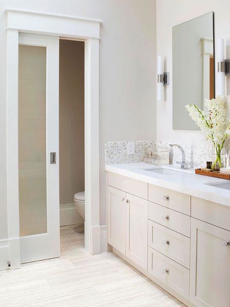 Calm & Comforting  One of the homeowner’s must-haves was a private toilet compartment, and with smart planning, they were able to incorporate one into this small 14x7-inch bathroom. The separate space includes extra towel storage, and the frosted-glass door admits light without sacrificing privacy. Floating mirrors flanked by linear sconces add to the room’s classic yet contemporary design. Toilette Design, Double Sinks, Toilet Room, Master Bath Remodel, Bilik Tidur, Ensuite Bathroom, Pocket Door, Bathroom Remodel Designs, Bad Design