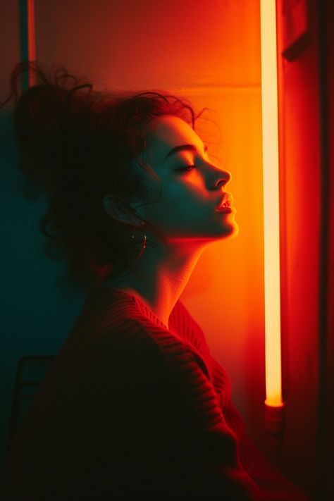 a woman sitting in front of an orange light in a dark room, in the style of turquoise and red, abstract photography, new american documentary photography, forms, multi-coloured minimalism, neon lighting, photo taken with provia --v 6 Orange Light Photography, Blue Light Photography, Light In A Dark Room, Backlit Photography, Photography Forms, Orange Lighting, Orange Photography, Lighting Reference, Lighting Photo