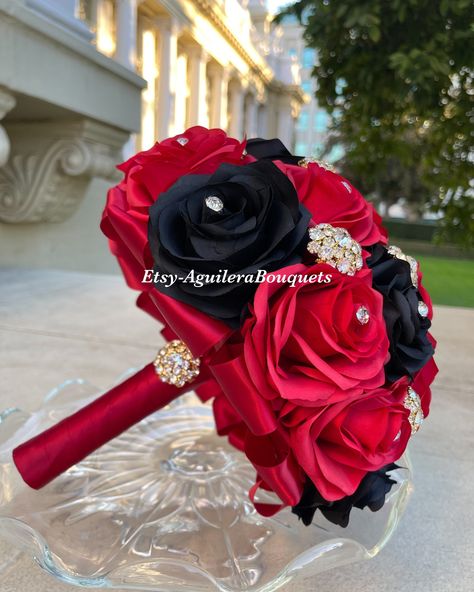 This bouquet is handmade with red and black roses with sparkling gold brooches. The handle of the bouquet is wrapped with satin ribbon. The design can be change if requested. I can do it in different colors. Please message me if the color is not listed.  *This bouquet is 10 inches in diameter*  If you need the bouquet sooner please sent me a message.  Please contact me if you have any questions:) Thank you so much! Quince Bouquet Red, Black Bridal Bouquet, Quince Bouquet, Quinceanera Flowers, Wedding Dress Cuts, Red And Gold Quince, Black Quince, Quinceanera Bouquet, Red Gold Wedding