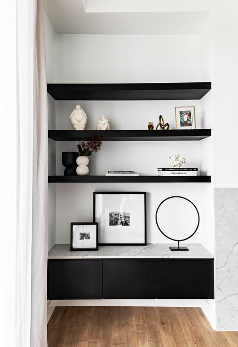 Contemporary black built in shelves in modern new build home in Sydney with timber floorboards. Storage in monochrome living room. #modernhome #livingroomstorage #shelves #monochrome #modernbuild #contemporaryhome #homebeautiful