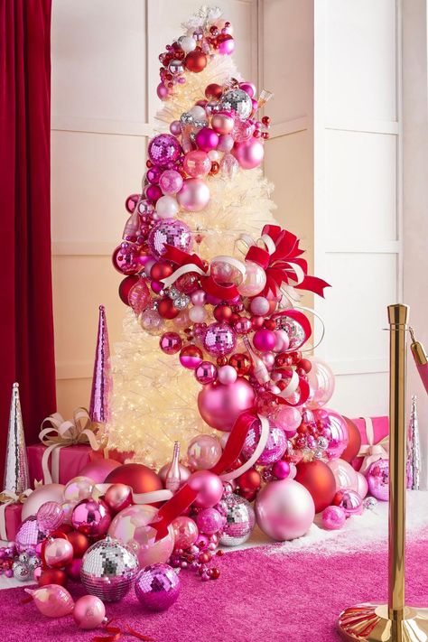 the 2024 A Blushing Holiday Christmas Tree from RAZ Christmas Tree Ball Garland, Pink Xmas Tree Decorating Ideas, Garland Archway Christmas, Christmas Pink Decorations, Red And Pink Christmas Decor, Pink Ornaments Christmas Tree, Pink And Red Christmas Tree, Pink And Red Christmas Decor, Hot Pink Christmas Tree